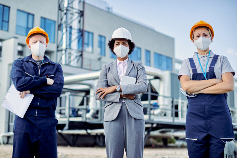 Team of confident civil engineers with protective face masks and